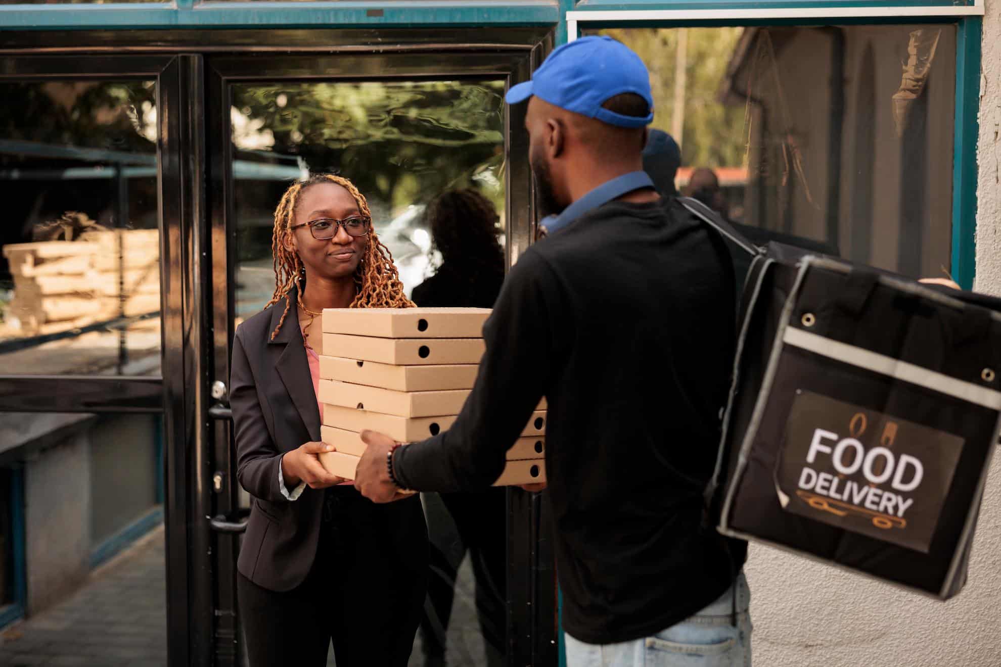 An image of a food delivery driver (contracted by a cloud kitchen) delivering the food to the customer.