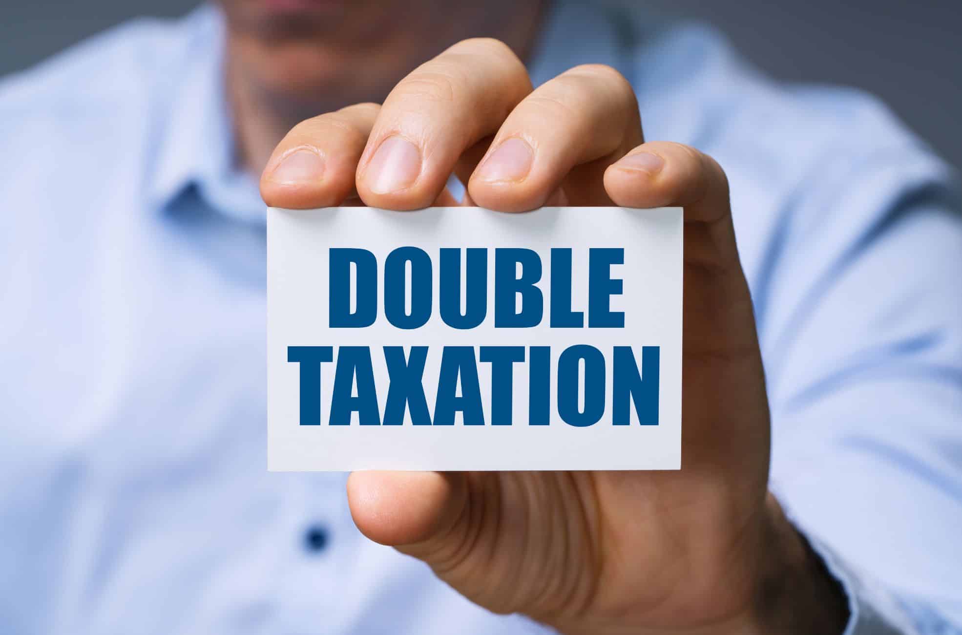 Business Man Holding Sign Saying Double Tax