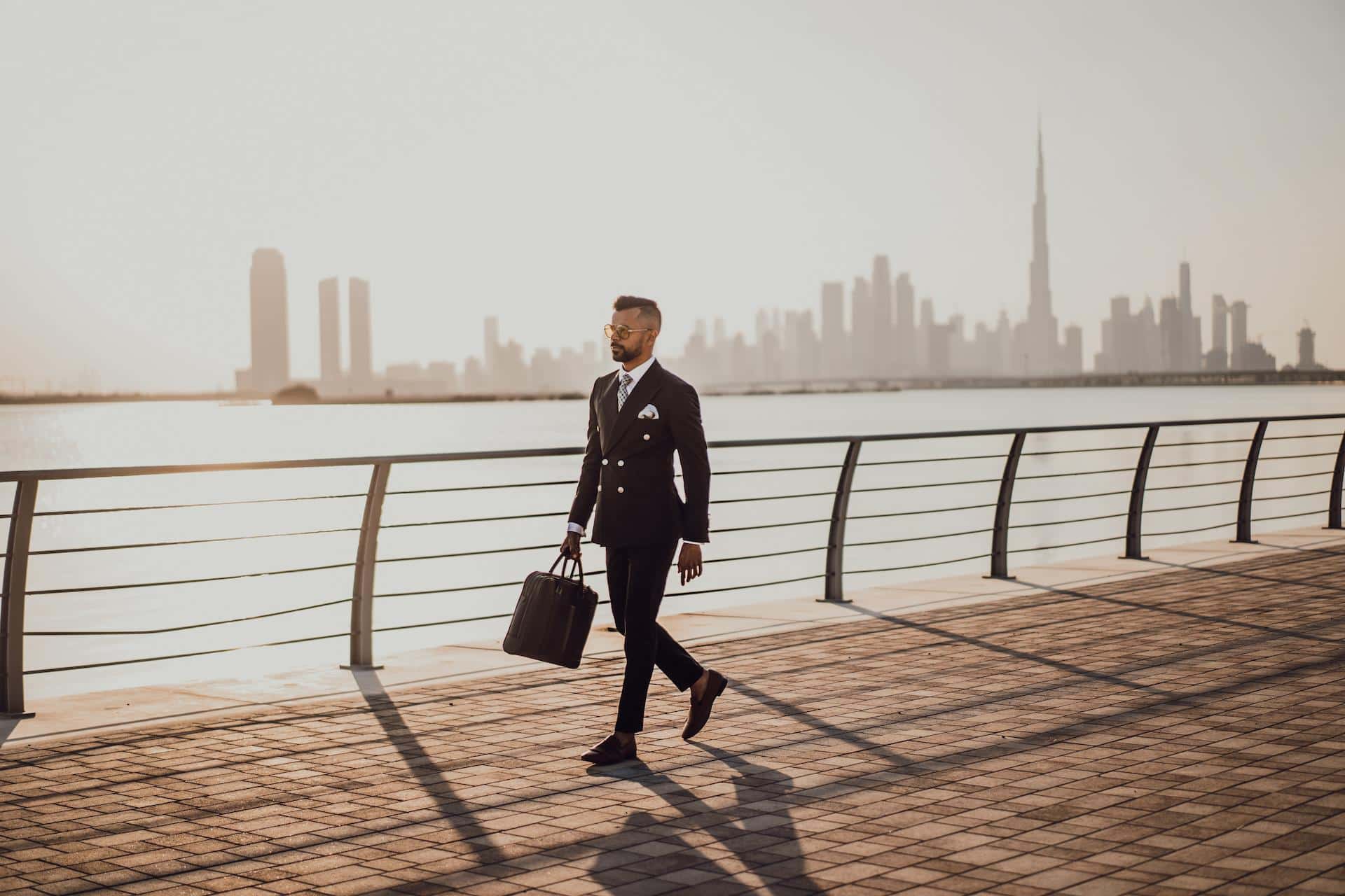 Man walking with briefcase along the river.