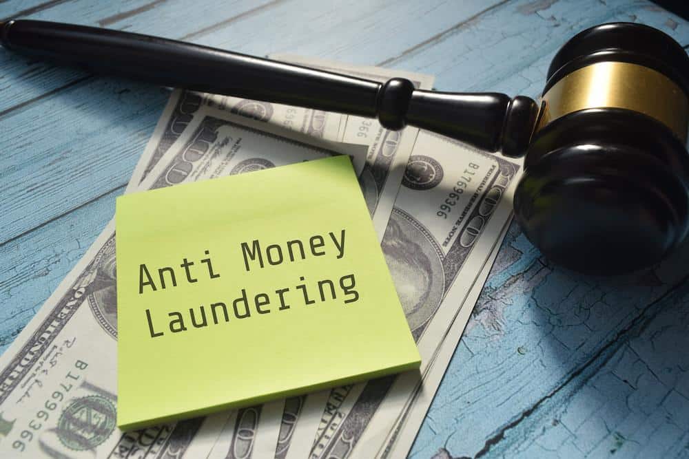 Cash and a gavel with a post it note saying Anti Money Laundering