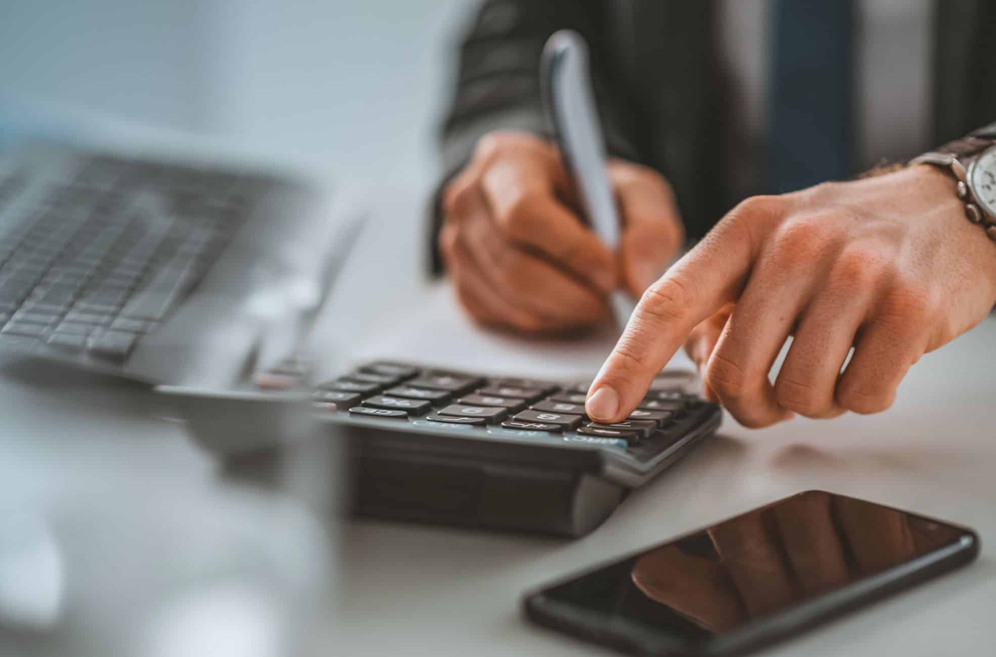 Man Doing Accounting Work On Calculator