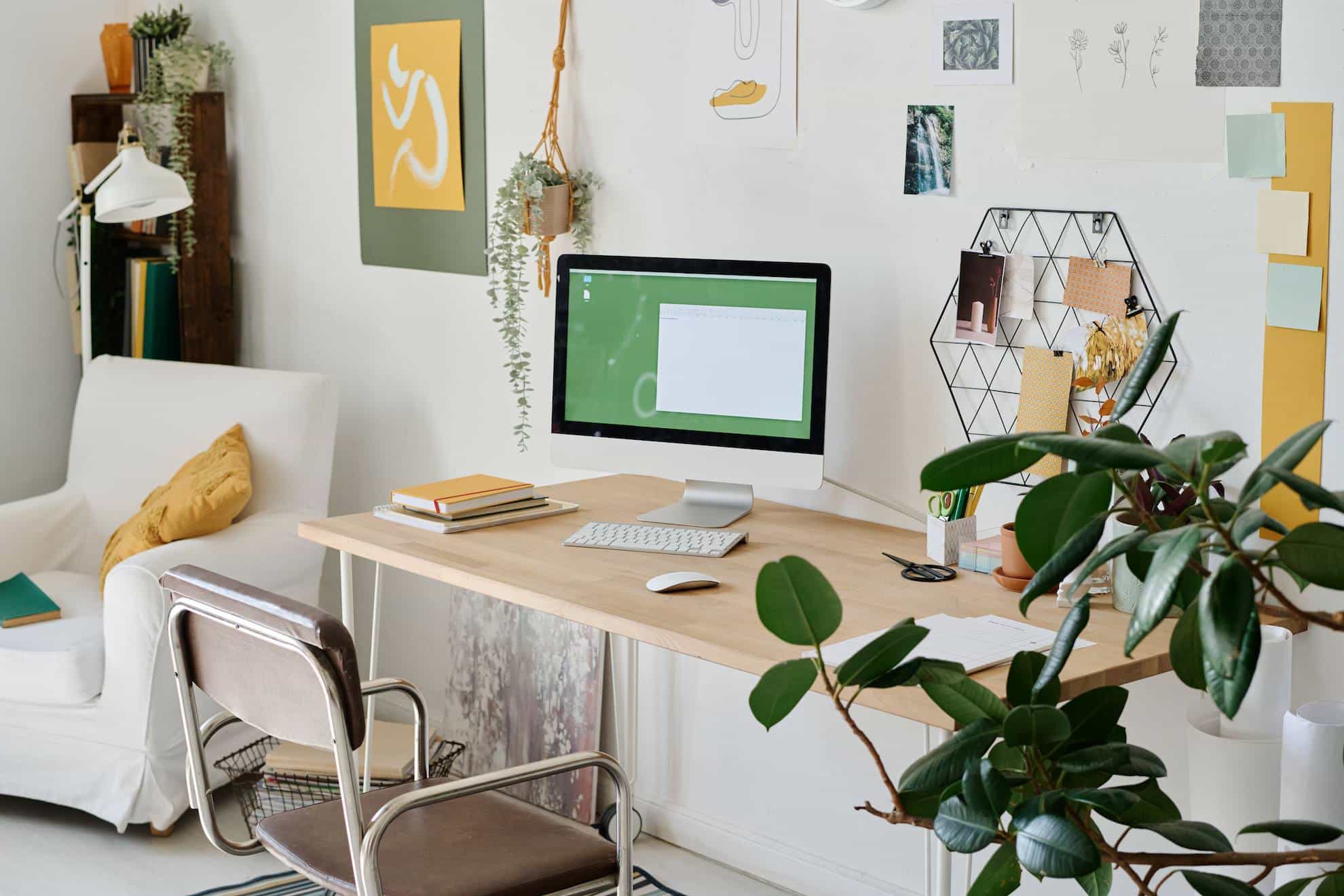 A picture of a home office in Dubai, with beautiful green plants on the desk.