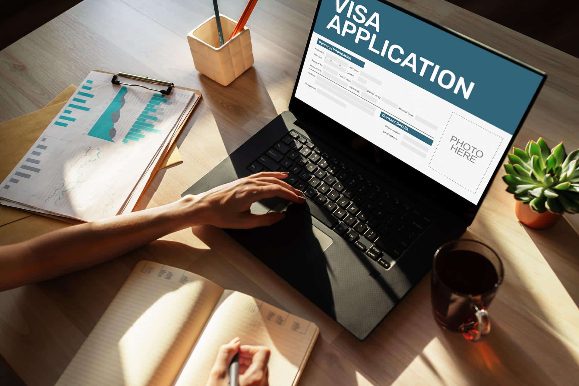 Top down view of a desk with a woman applying for UAE Silver Visa on her laptop